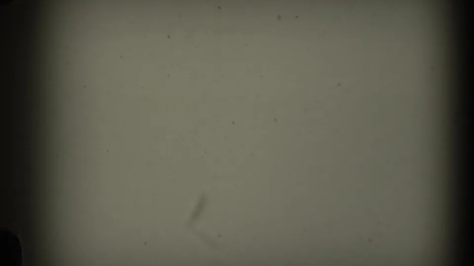 1969 California 8mm home-movie frame showing blank film texture, gate shadow, dust, grain, and a faint lower-left mark.