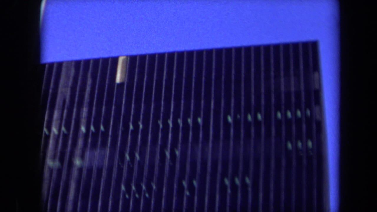 Close low-angle view of the skyscraper facade with vertical ribs and dark windows.