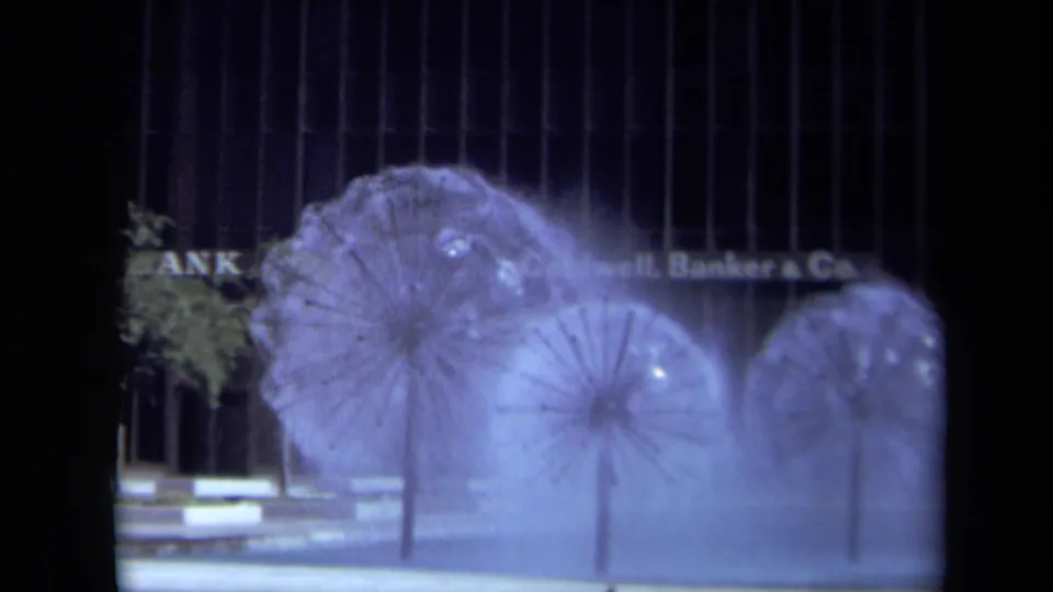 1969 California 8mm view of sculptural public fountains with mist softening the Coldwell Banker & Co. sign behind them.