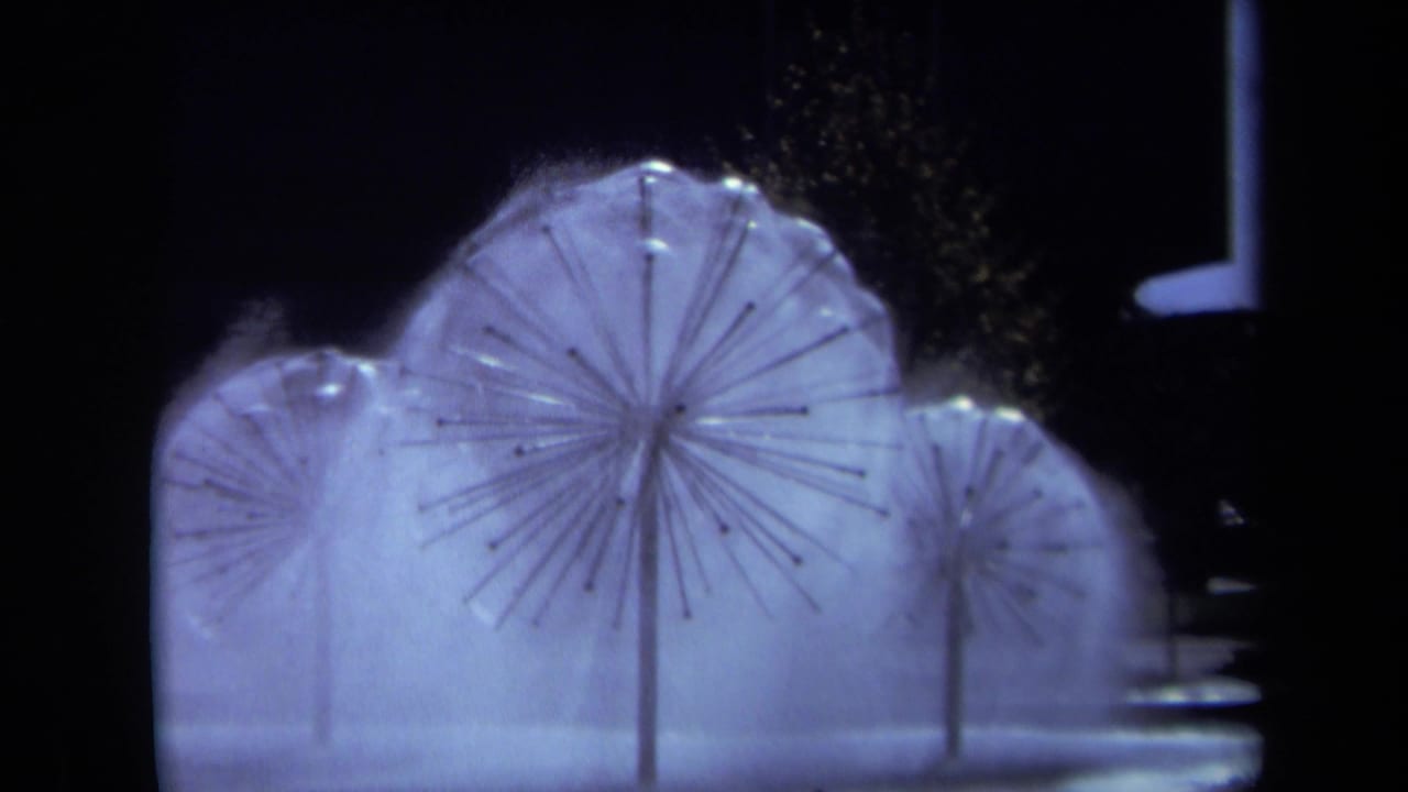 1969 Sacramento 8mm frame showing illuminated circular fountain heads with radiating spokes and misting water at night.