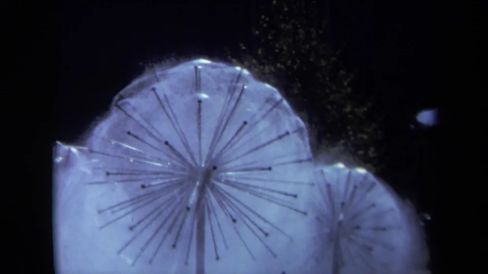 1969 Sacramento 8mm frame emphasizing a large illuminated circular fountain head, radiating spokes, and drifting water spray.