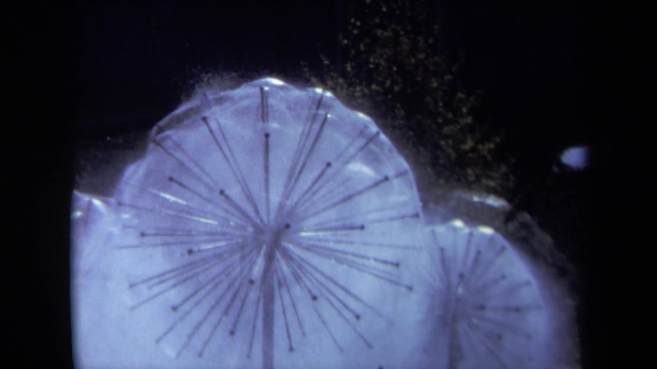 1969 Sacramento 8mm frame showing a snowflake-shaped sprinkler head with radiating arms and pale water spray in close-up.
