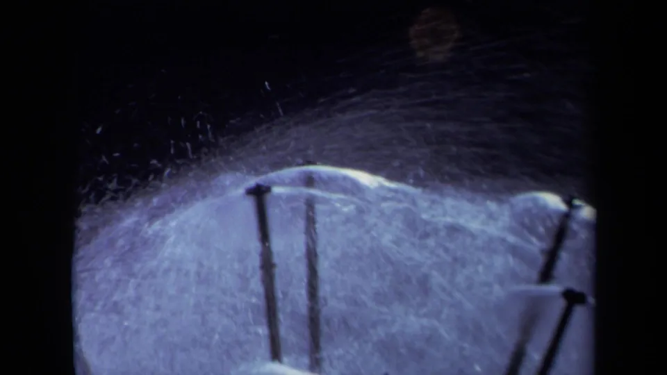 Final 1969 Sacramento 8mm frame showing sprinkler stakes at the lower edge with water spray arcing across a wet yard surface.