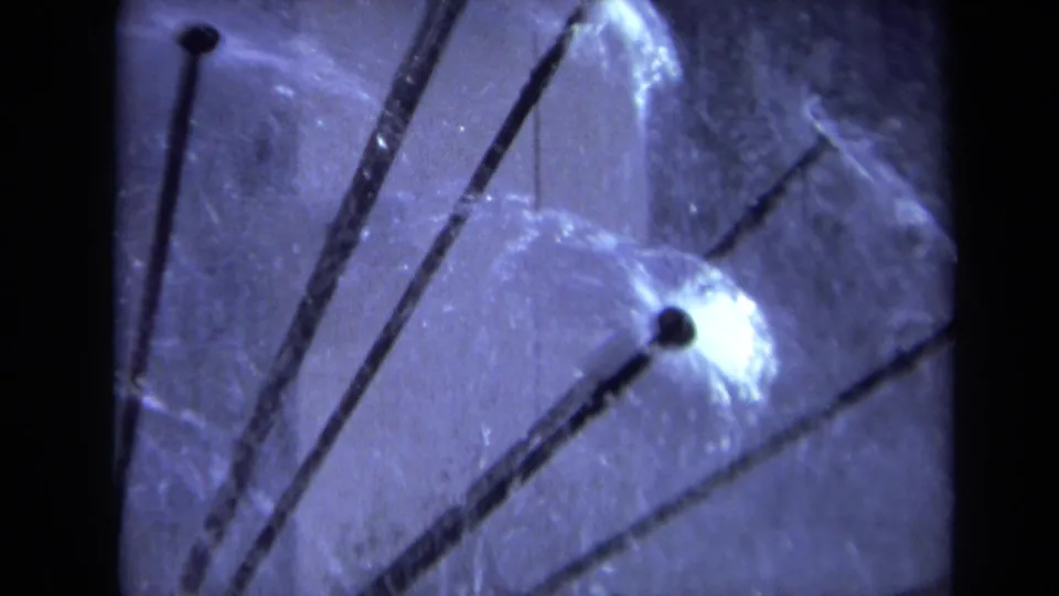 Close 8mm view from the 1969 Sacramento clip showing sprinkler rods, a nozzle, and reflected water on the translucent globe.