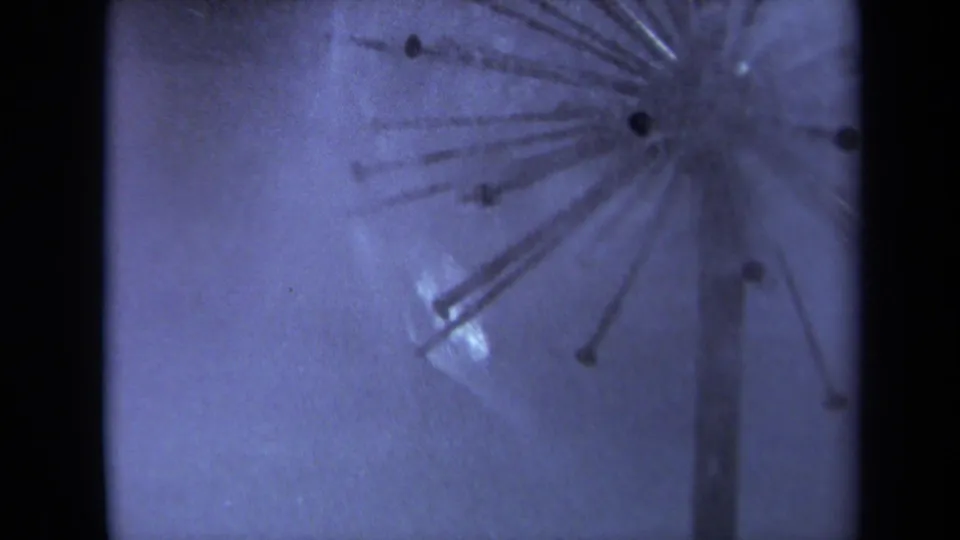 1969 Sacramento 8mm frame with a soft, cool-toned view of sprinkler spray, radial lines, and a pale background.