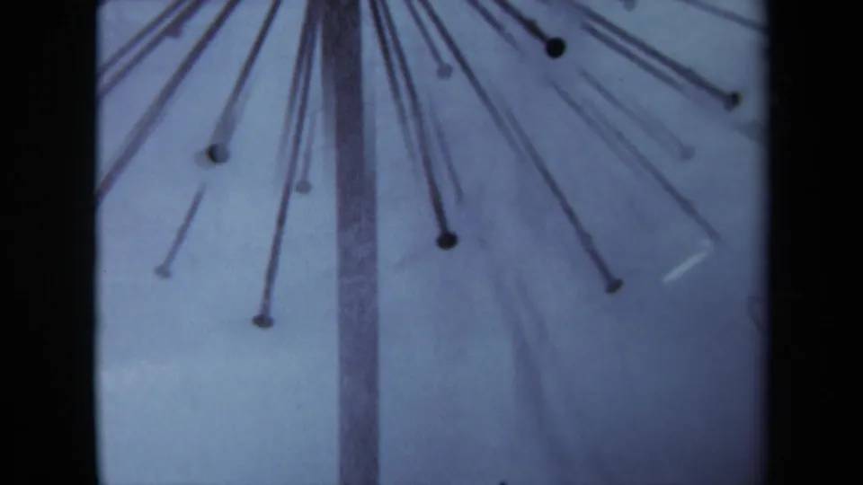 1969 Sacramento home-movie frame showing a central pole with nails radiating outward like a small sunburst.