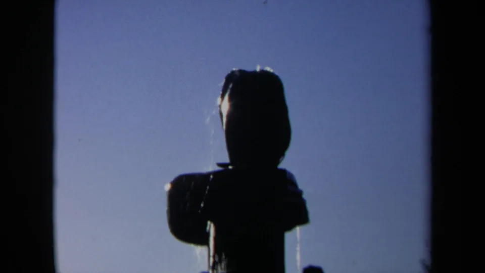 Close 1969 Sacramento 8mm view of the abstract fountain's upper structure, mostly silhouetted against an open blue sky.