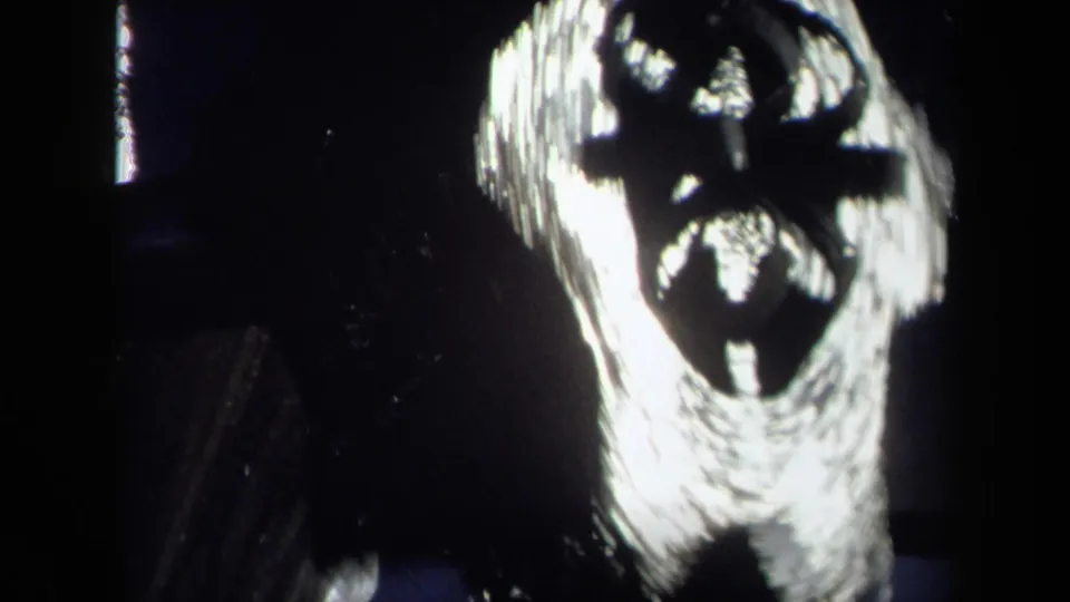 1969 8mm frame from Sacramento metadata showing water making high-contrast abstract shapes against a dark field.