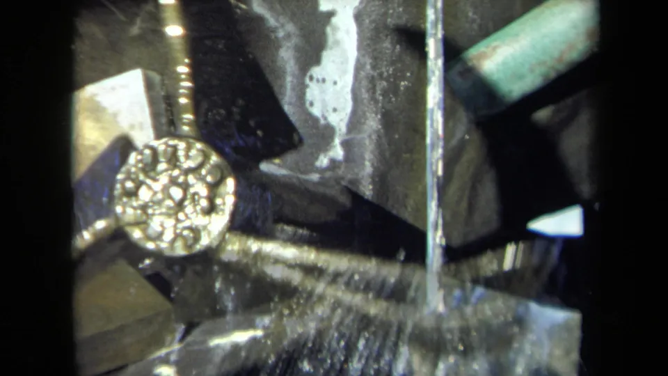 Final close frame of the 1969 Sacramento mill machinery, showing the gold-colored rotating element amid water and dark wet metal.