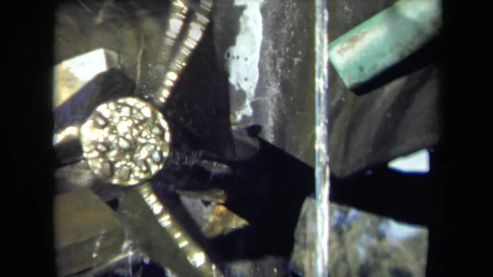 1969 Sacramento 8mm close-up of a textured metal wheel or hub beside wet dark mill machinery and moving water.