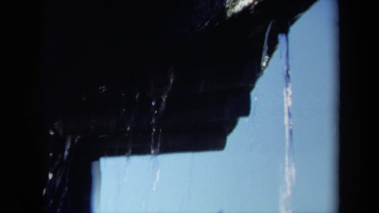 1969 Sacramento home-movie frame showing a close-up of a dark wet boat propeller blade with water streaming against blue sky.