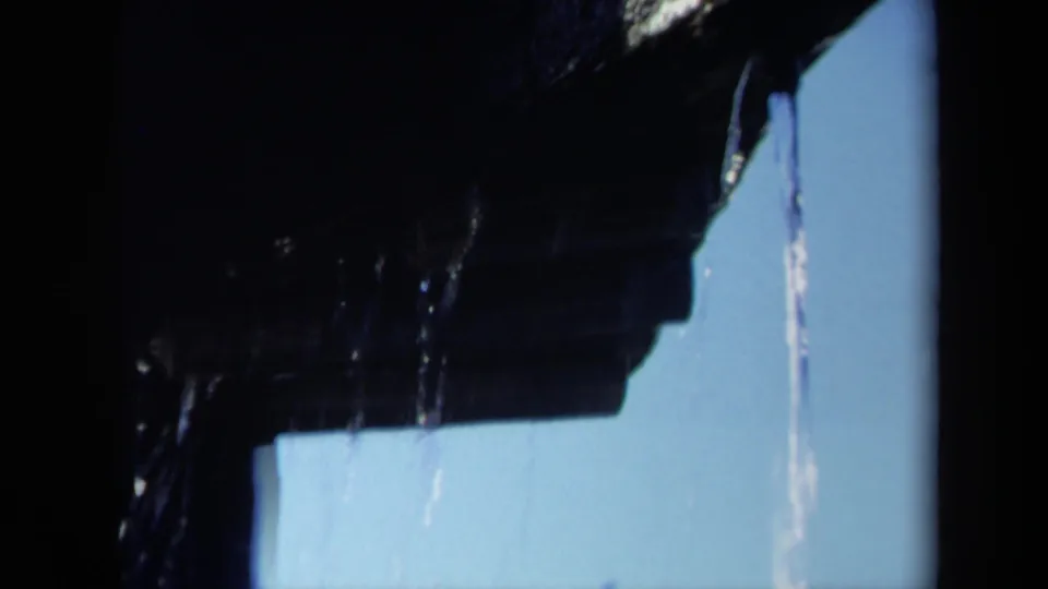 1969 Sacramento home-movie frame showing a close-up of a dark wet boat propeller blade with water streaming against blue sky.