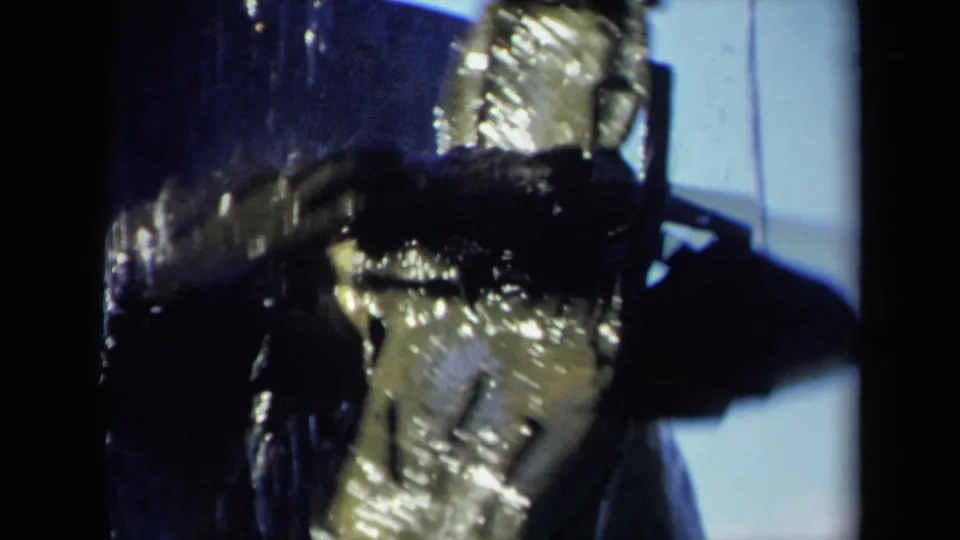 Close 8mm view of wet boat machinery in the 1969 Sacramento clip, with the propeller and shaft partly obscured by shadow and frame edges.