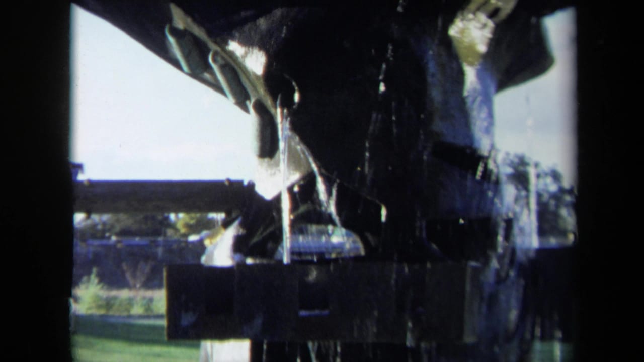Close view of water pouring from a dark tiered fountain shape.