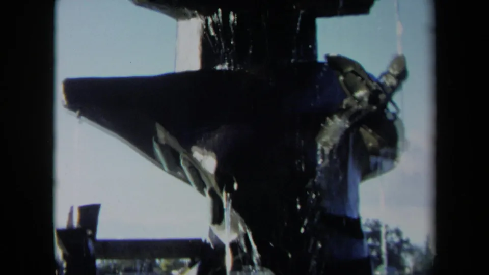 1969 Sacramento 8mm footage frame with the fountain filling most of the view as water runs over its dark surfaces.