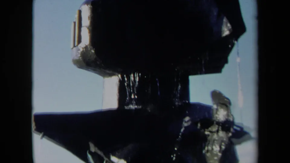Final 1969 Sacramento frame showing the upper portion of the dark fountain tower with water dripping against a bright sky.