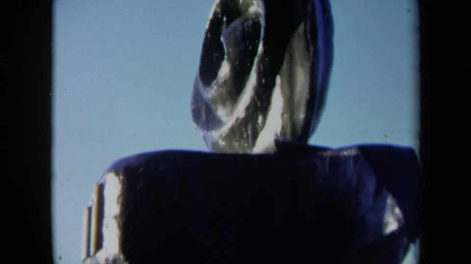 Close 8mm view of the Sacramento abstract fountain, with the spiral blade-like form partly cropped above a dark basin.