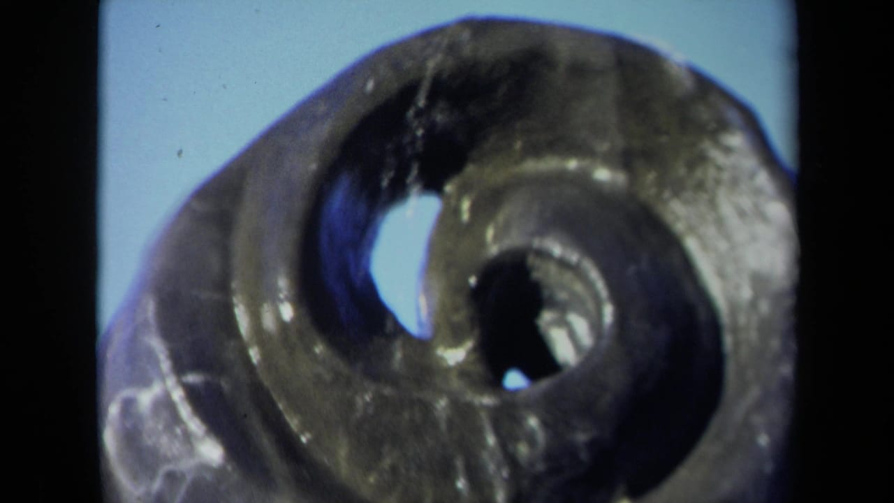 1969 Sacramento 8mm close-up of the bronze spiral fountain, emphasizing the center openings and shiny weathered metal.