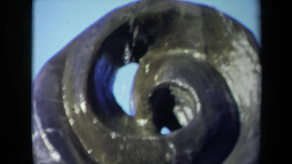 1969 Sacramento 8mm frame with a tight handheld view of the bronze spiral fountain and its overlapping center openings.