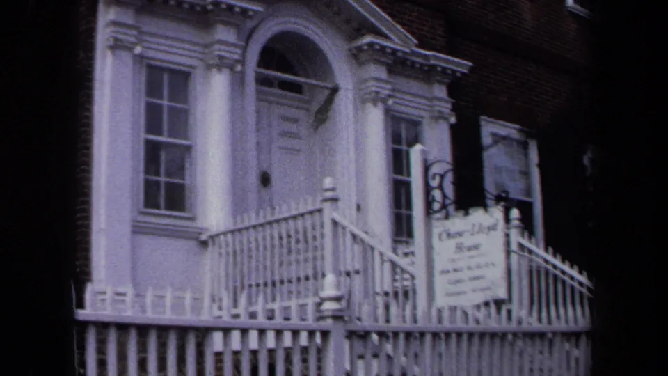 The zoom moves closer to the Chase Lloyd House sign beside the white entrance, with railings and window details visible.