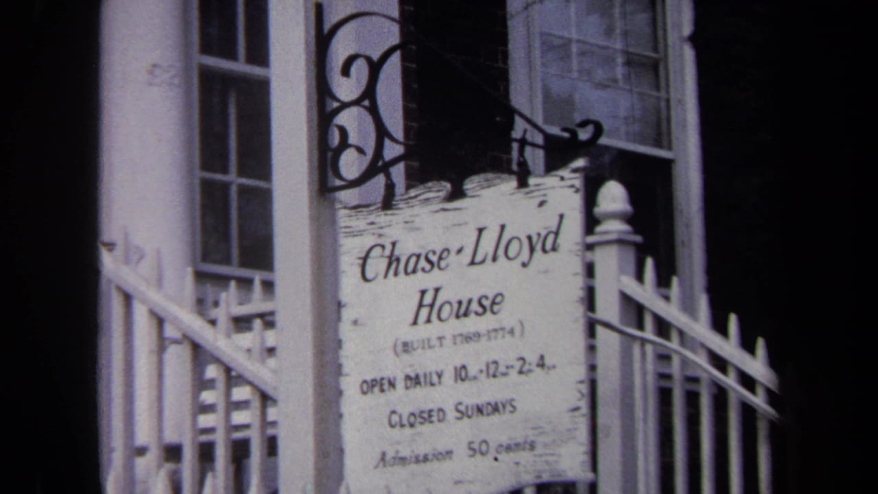 Weathered Chase-Lloyd House sign beside a white fence and doorway.