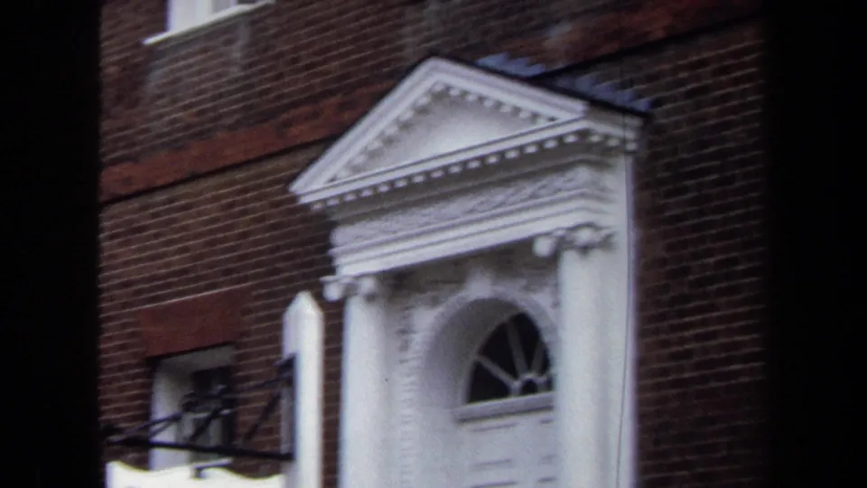 1970 Annapolis frame of the Hammond-Harwood House entrance with a white pediment, columns, arched fanlight, and red brick wall.