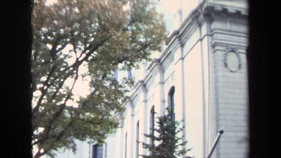 Annapolis exterior detail with arched windows, pale stone walls, trees, and a dark edge from the film or camera framing.