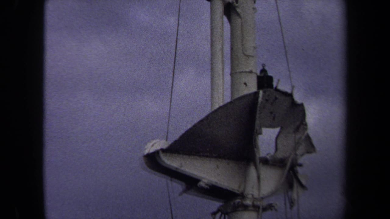 1970 Annapolis 8mm frame showing a torn, weathered hanging object beside a pole or mast against a cloudy sky.