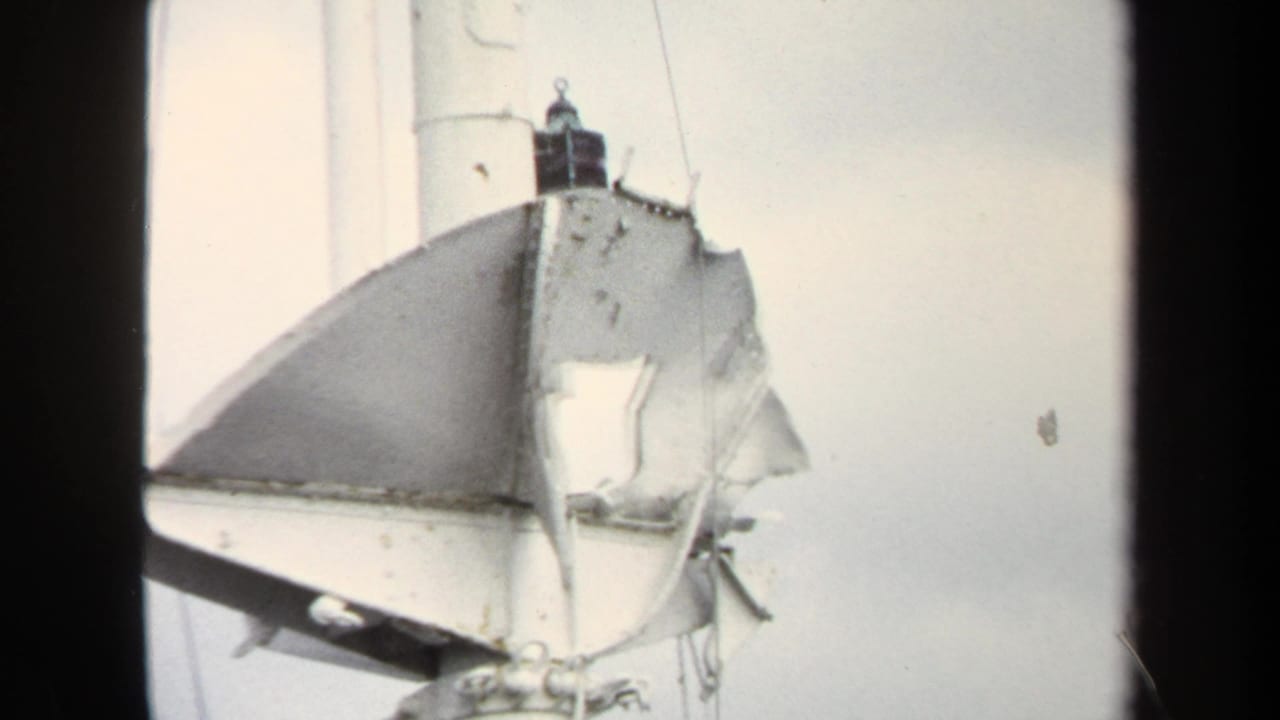 1970 Annapolis 8mm frame showing a close view of a white sailboat mast with torn sail material or cover and rigging lines.