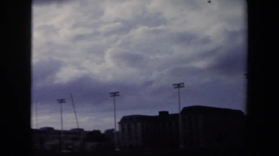 1970 Annapolis home-movie view of stadium floodlights and silhouetted structures, with soft grain and muted color.