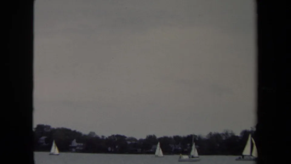 1970 Annapolis sailing view with several small boats spread across the horizon in a home-movie frame.
