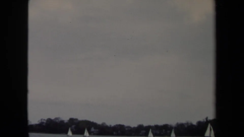 1970 8mm Annapolis frame with small white sails low on the water beneath a pale overcast sky.