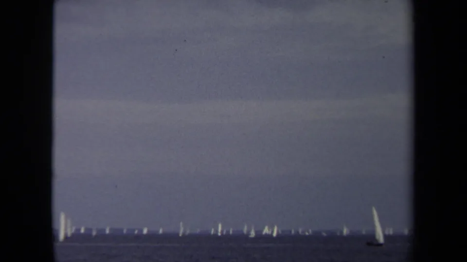 Soft 8mm Annapolis frame with distant sailboats across the water and a nearer white-sailed boat at lower right.
