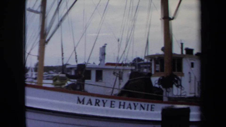 1970 Annapolis harbor frame with the MARY E HAYNIE name clearly visible on a white boat beneath masts and rigging.