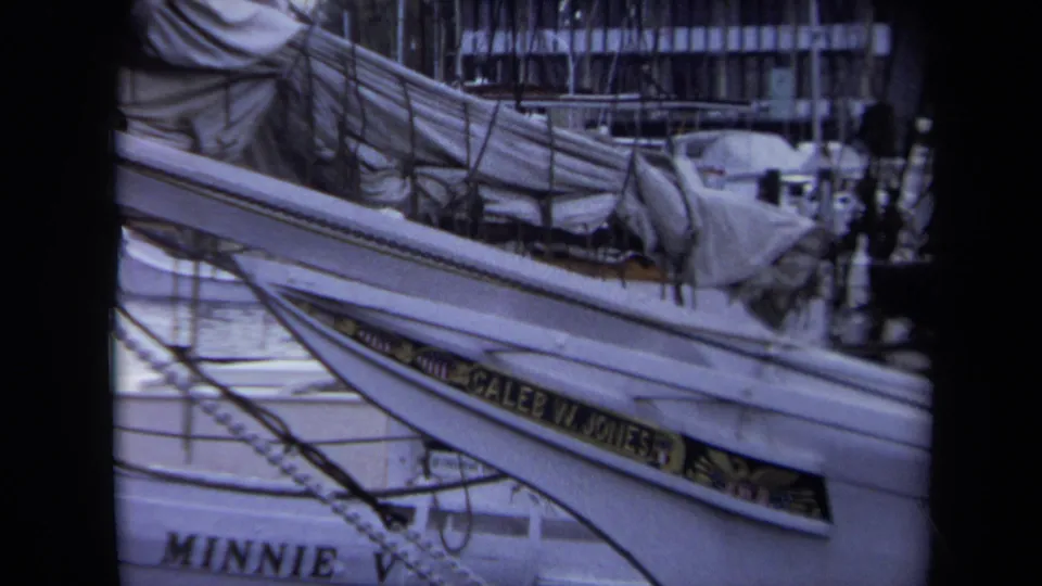 1970 Annapolis marina footage shows a close, slightly soft view of sailboat rigging, covered gear, and visible Caleb W. Jones and Minnie V. boat names.