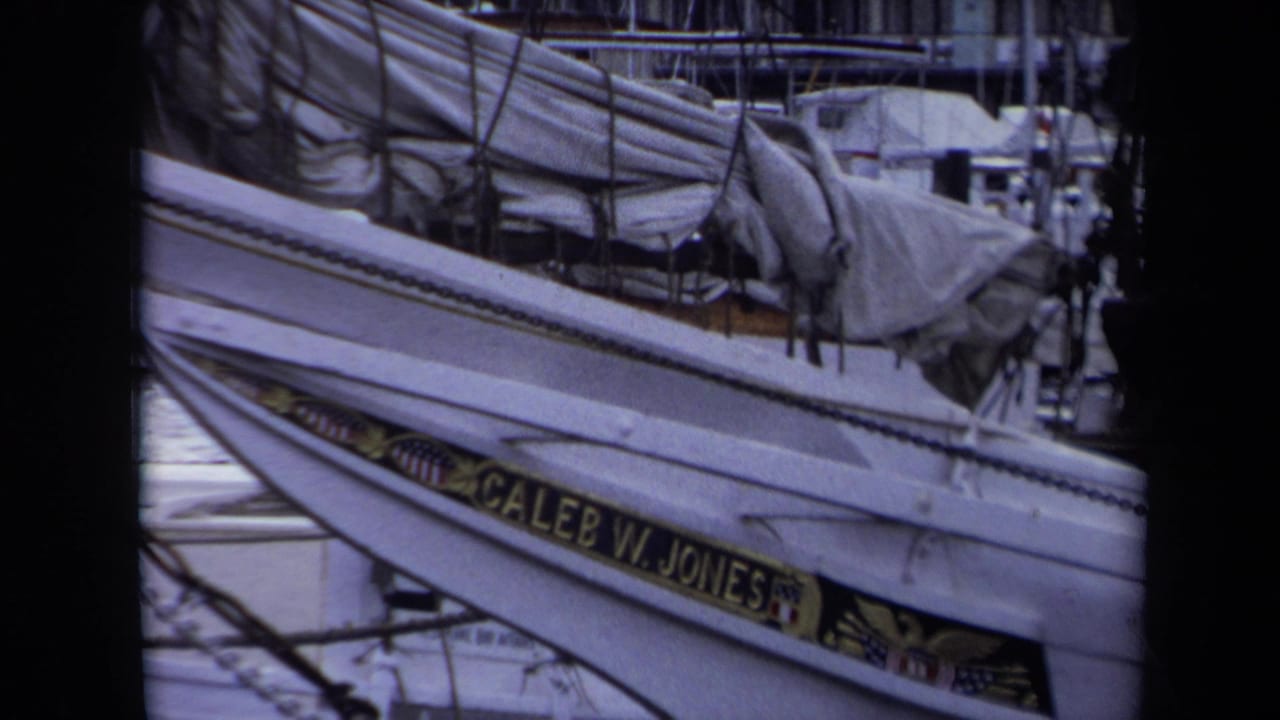 1970 Annapolis marina frame with the Caleb W. Jones nameboard, rigging, canvas covers, and nearby docked boats in soft 8mm color.