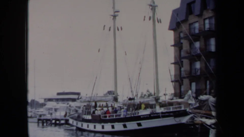 The final frame holds on the docked Mystic Whaler in Annapolis, with people aboard and waterfront architecture visible behind the rigging.