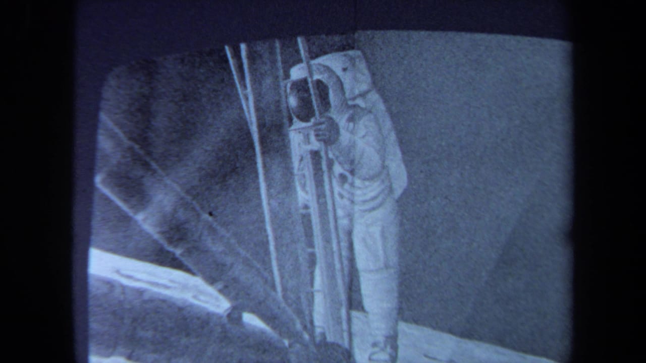 1970 California 8mm frame showing a blue-toned sketch or projected view of a lunar-module scene with ladder-like details.