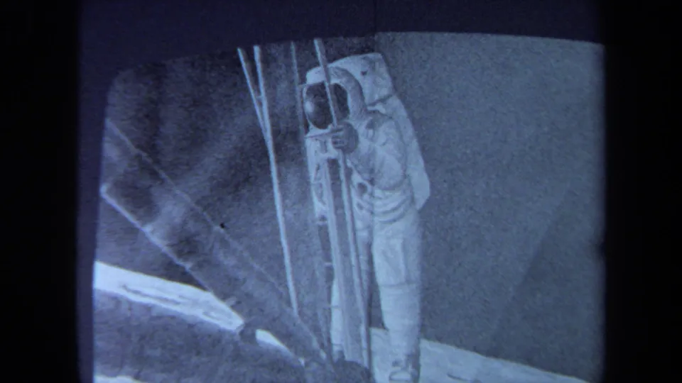 1970 California 8mm frame showing a blue-toned sketch or projected view of a lunar-module scene with ladder-like details.
