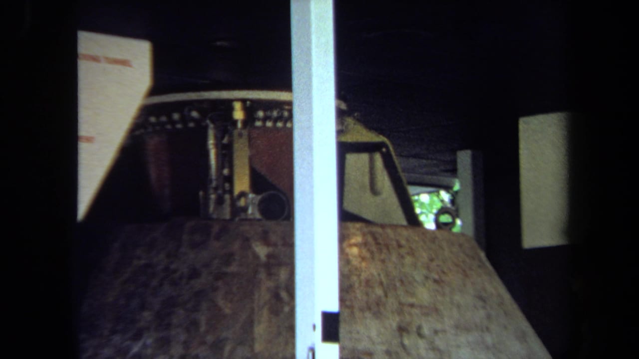 1970 California home-movie frame with a closer view of a lunar-module model, angular surfaces, and exhibit framing.