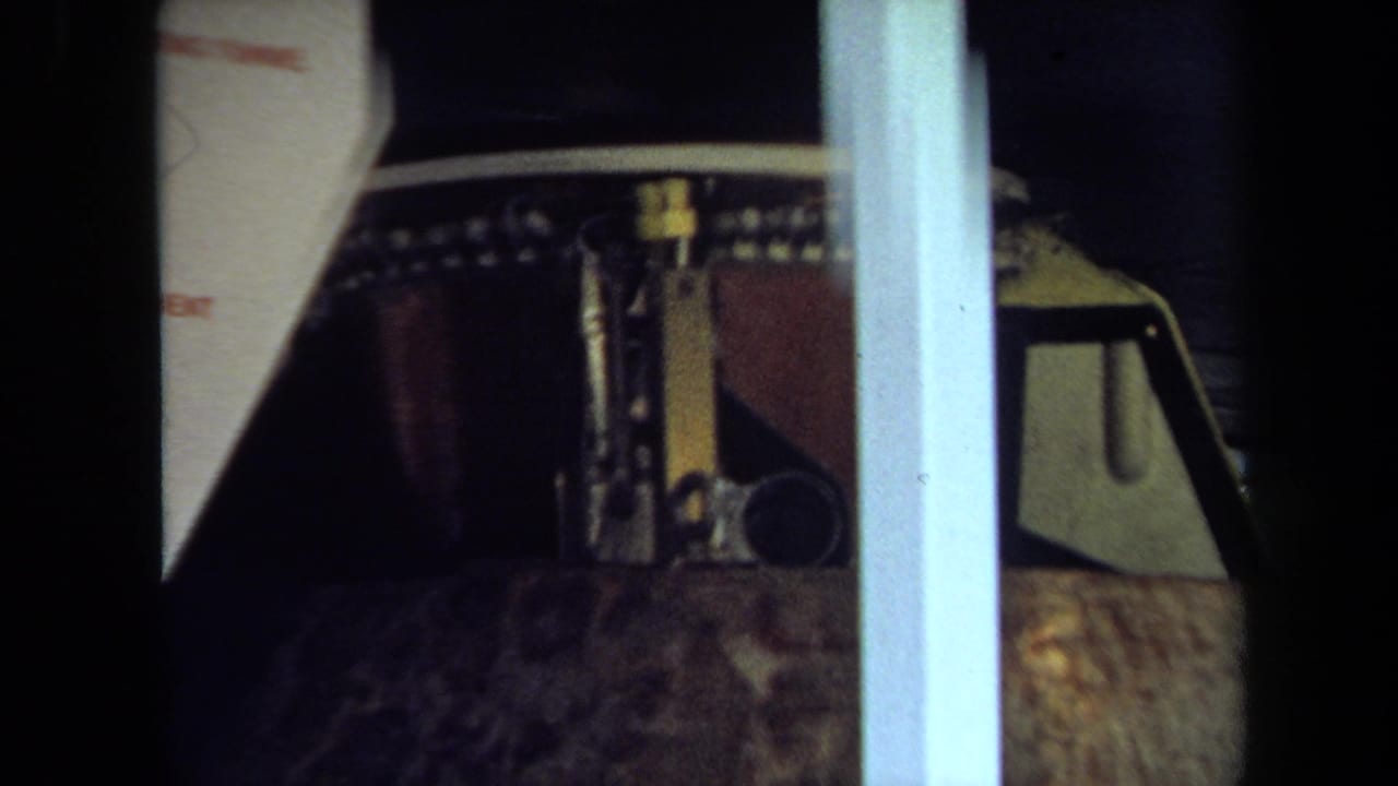 Close view of the float top and brown cylindrical section behind a pale vertical post.