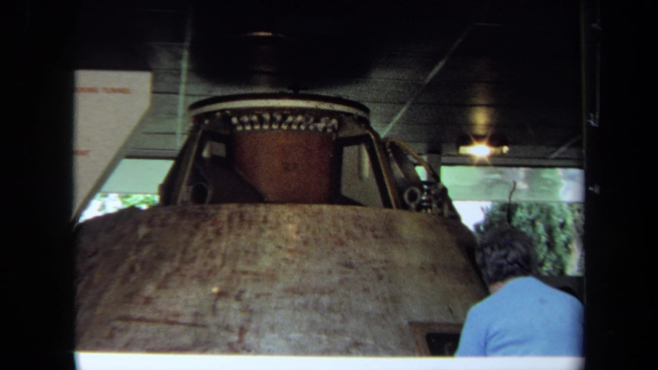 1970 California 8mm frame showing the brown float form indoors as a person in a blue shirt observes from behind.