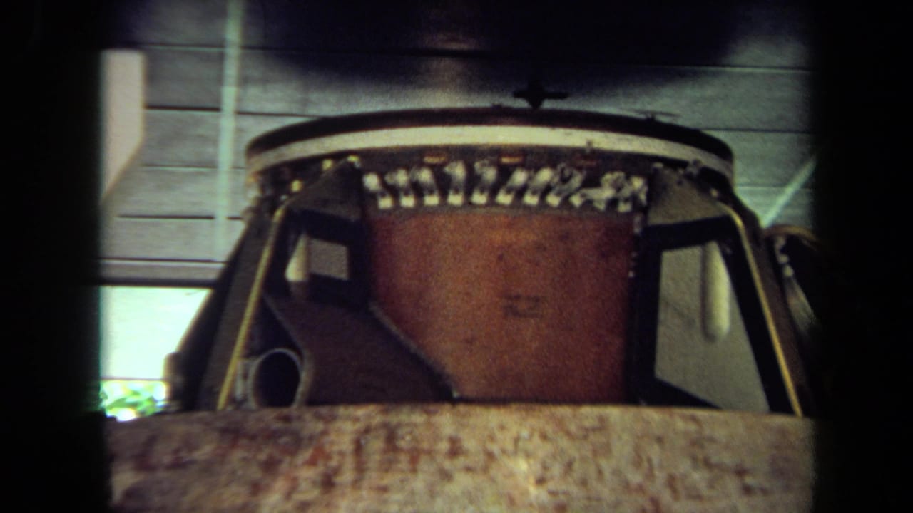 1970 California 8mm frame showing a close view of a spacecraft capsule, with ceiling panels and exhibit lighting above.