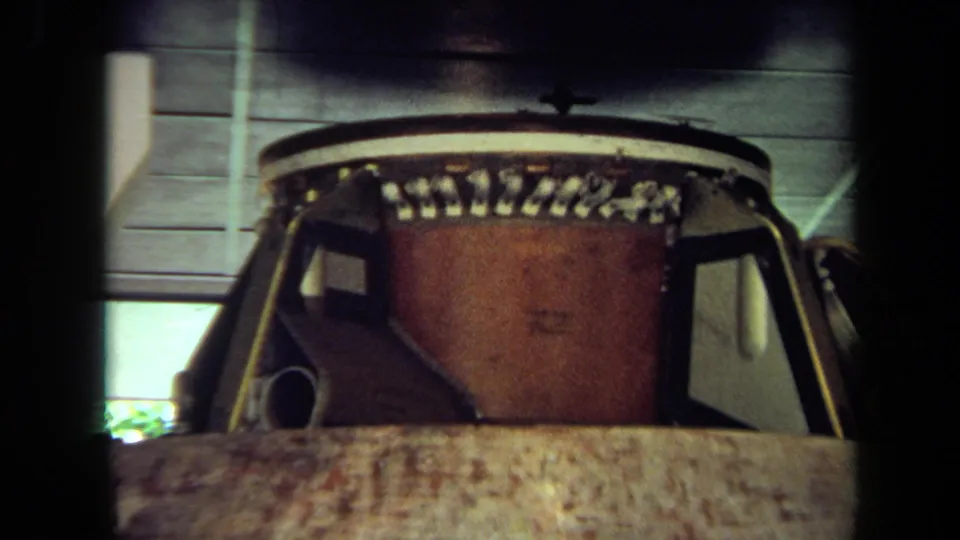 1970 California 8mm frame showing a close view of a spacecraft capsule, with ceiling panels and exhibit lighting above.