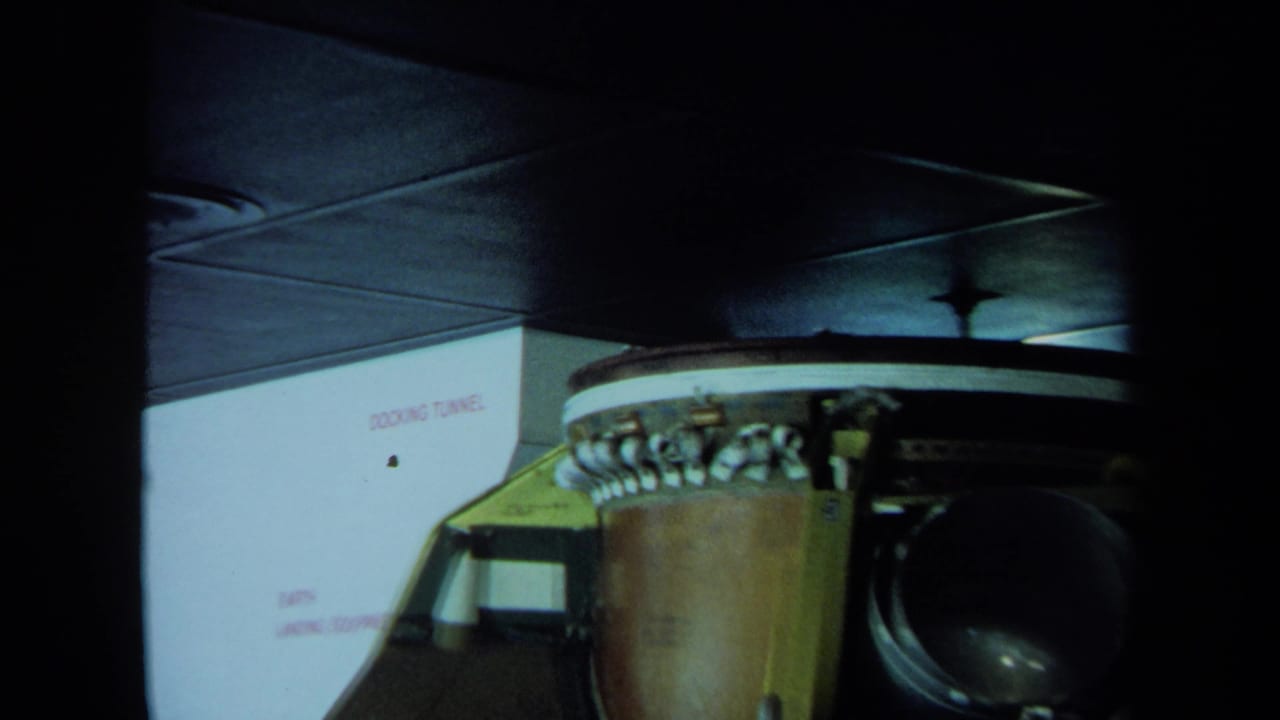 Cylindrical machinery and wiring near a wall labeled docking tunnel.
