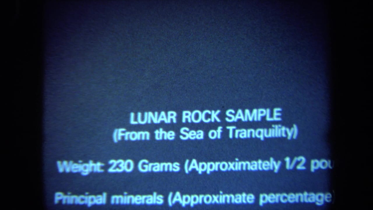 A blue-toned text screen identifies a lunar rock sample from the Sea of Tranquility and lists weight and mineral information.