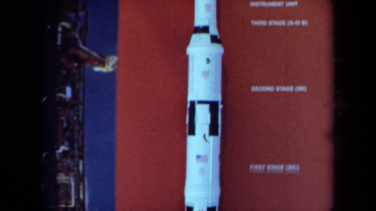Close view of a rocket display with stage labels on a red panel.