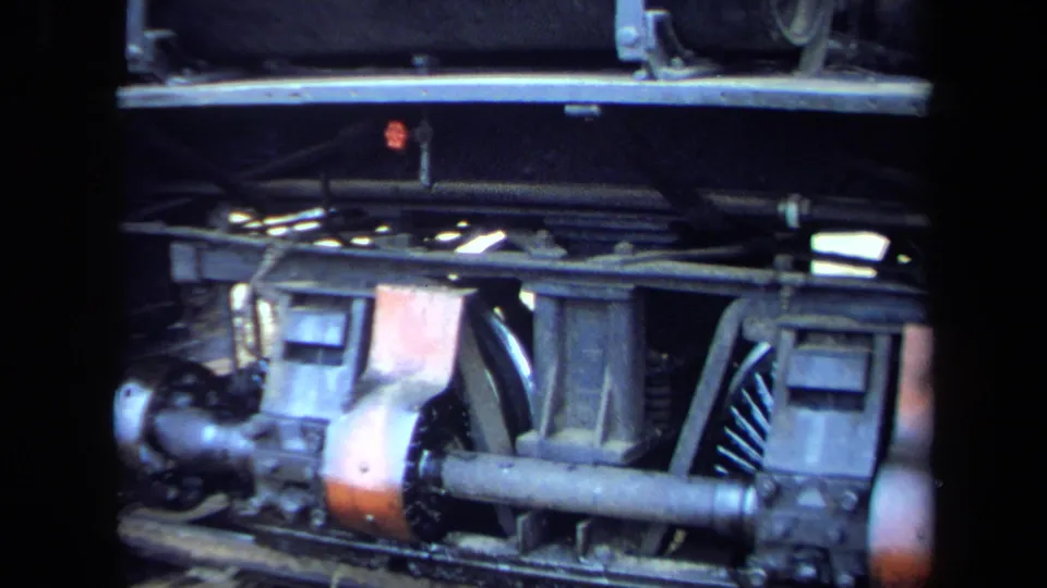 1970 8mm California frame showing locomotive wheels, axle, rods, and undercarriage components beneath a dark side panel.