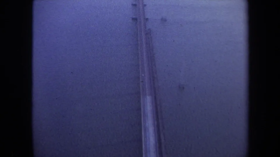 Final visible frame holds on the bridge over water in the 1970 Washington, DC travel footage, with strong blue cast and physical film specks.