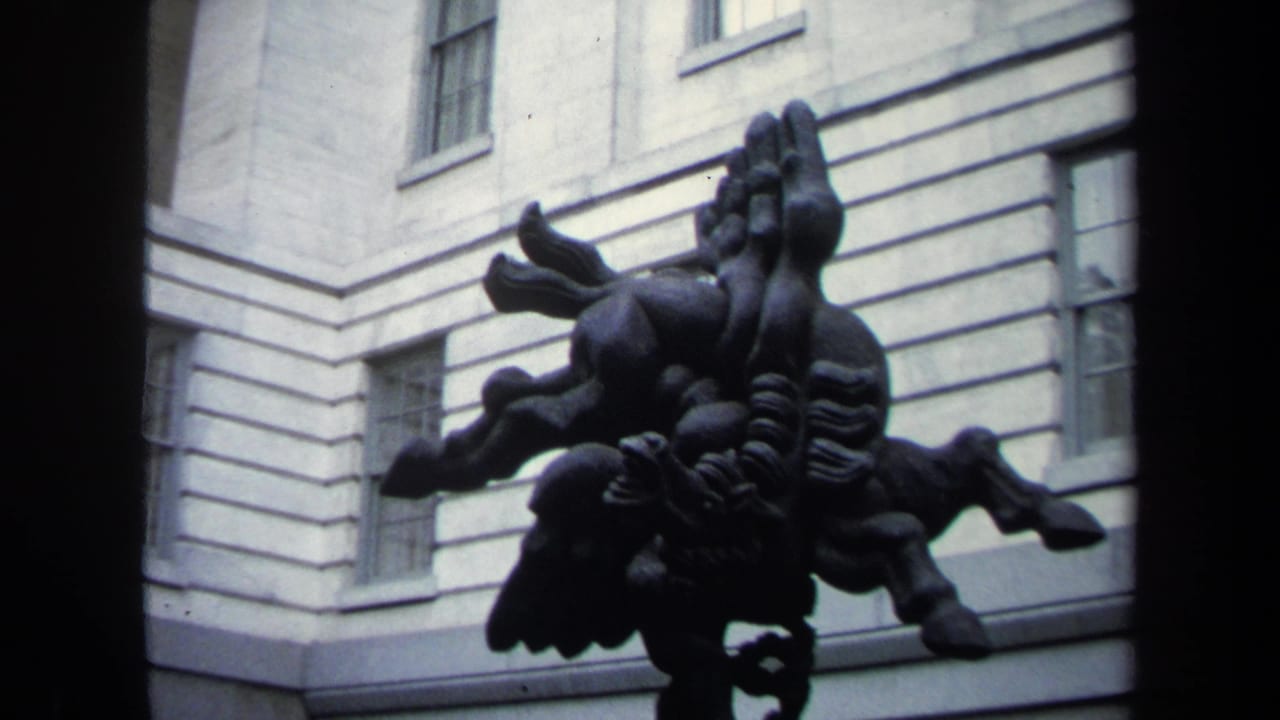 1970 Washington DC 8mm frame showing a dark abstract horse-like sculpture against a pale institutional facade with tall windows.
